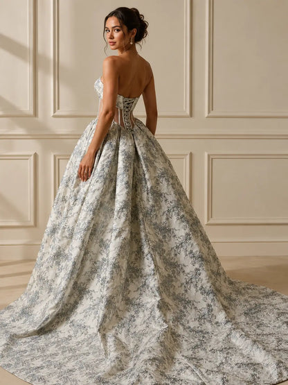 Dusty blue jacquard wedding dress with a strapless corset bodice, lace-up back, and a voluminous floor-length ballgown skirt.