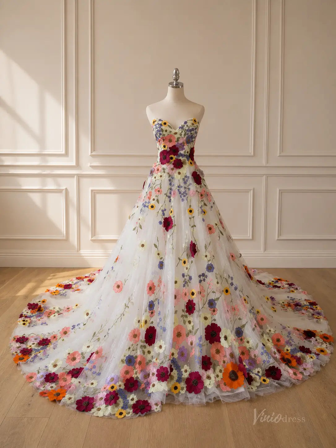 Strapless white ball gown featuring a full skirt and bodice adorned with vibrant, multicolored 3D floral appliqués.