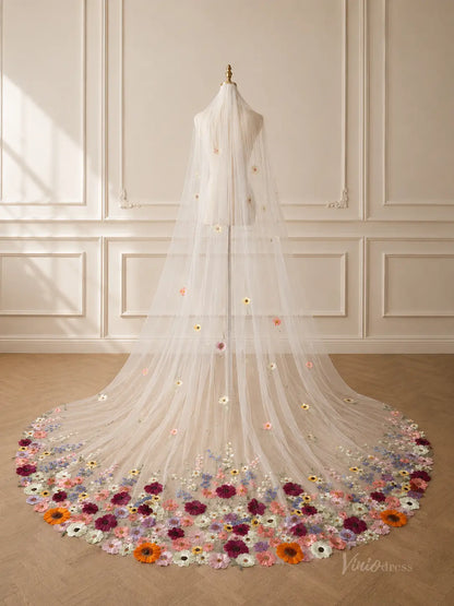 Long ivory tulle wedding veil featuring scattered 3D floral appliqués and a dense, colorful wildflower hem design.