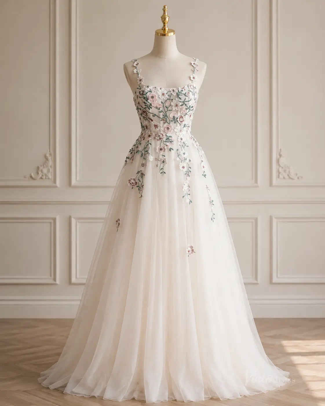 A-line tulle wedding dress featuring delicate floral embroidery, spaghetti straps, and a romantic floor-length skirt.