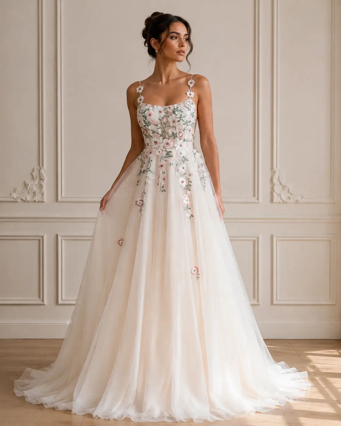 A-line wedding dress with floral embroidery, spaghetti straps, and a flowing tulle skirt in ivory and soft pink.