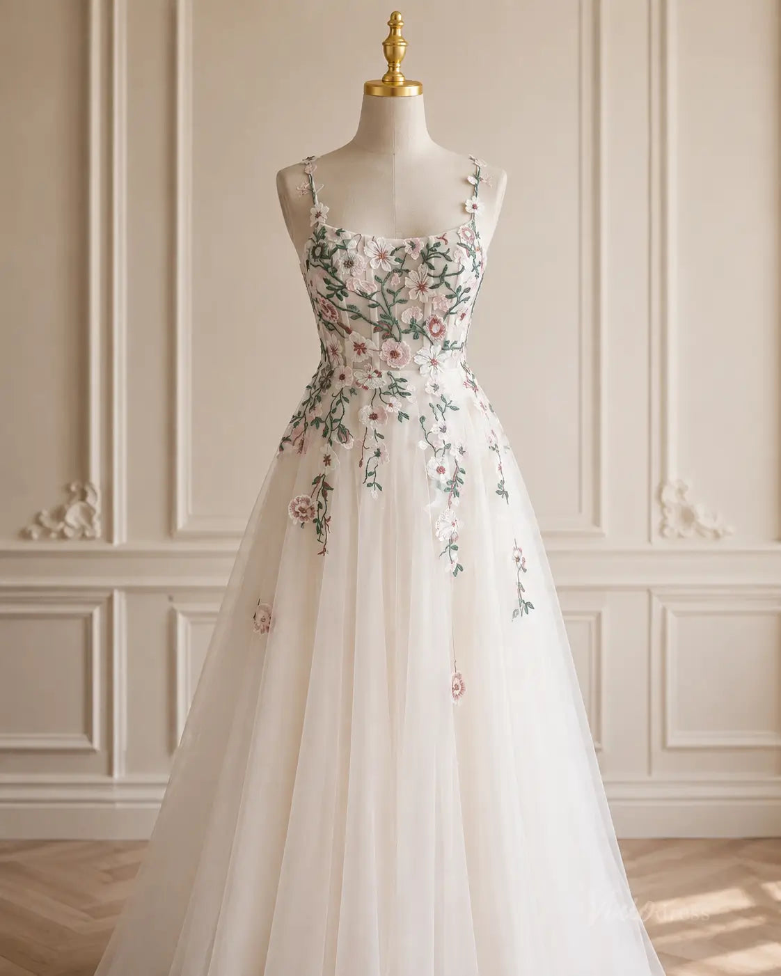 A-line tulle wedding dress with delicate floral embroidery, spaghetti straps, and a sweetheart neckline on a mannequin.