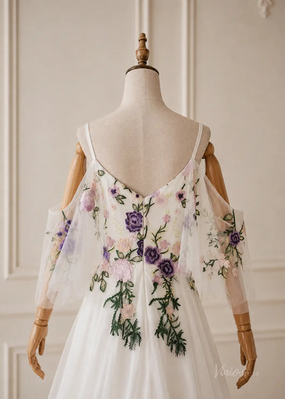 White pleated chiffon dress with cold-shoulder sleeves and colorful floral embroidery on a mannequin.