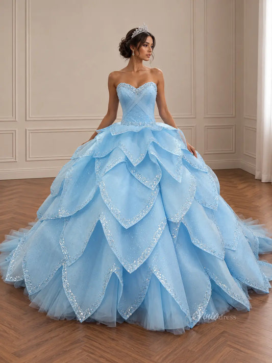 Light blue quinceañera ball gown with a crystal sweetheart bodice and a voluminous, glittery layered petal skirt.