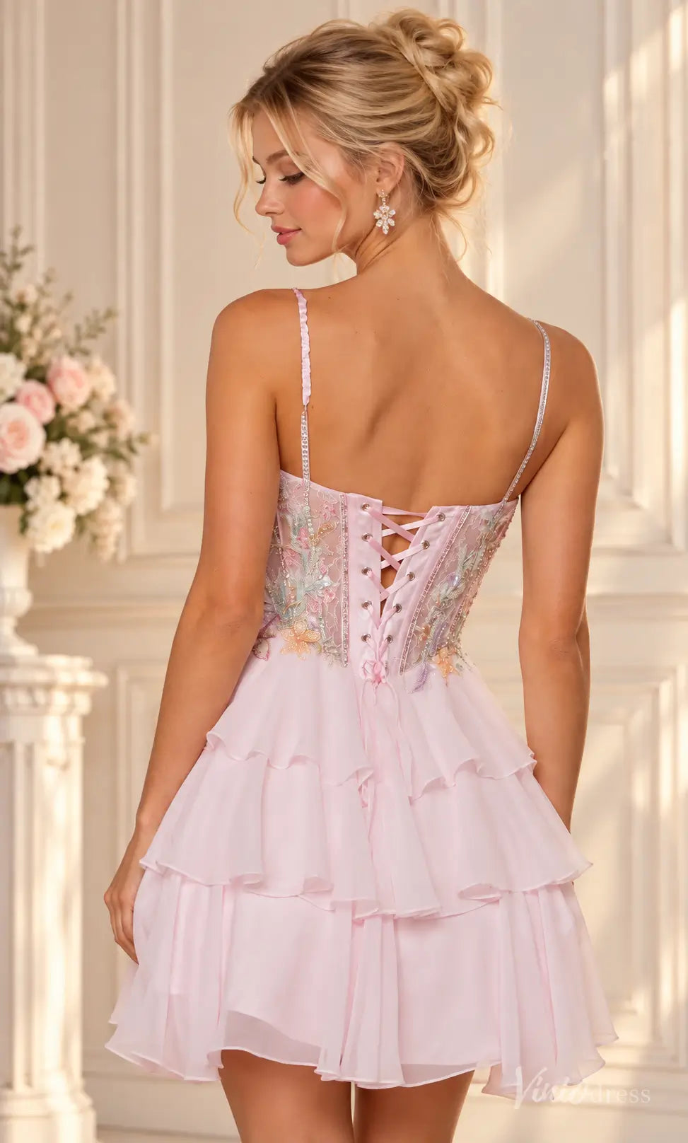 Blush pink homecoming dress with floral embroidery, beaded corset bodice, lace-up back, and a tiered ruffle mini skirt.