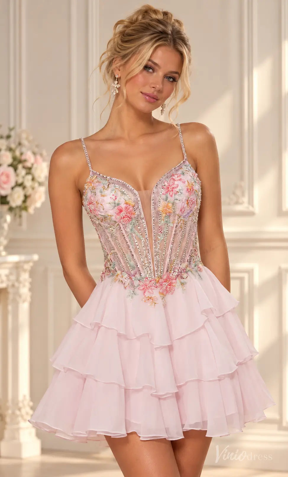 Blush pink homecoming dress with floral embroidery, beaded corset bodice, and a tiered ruffle mini skirt.