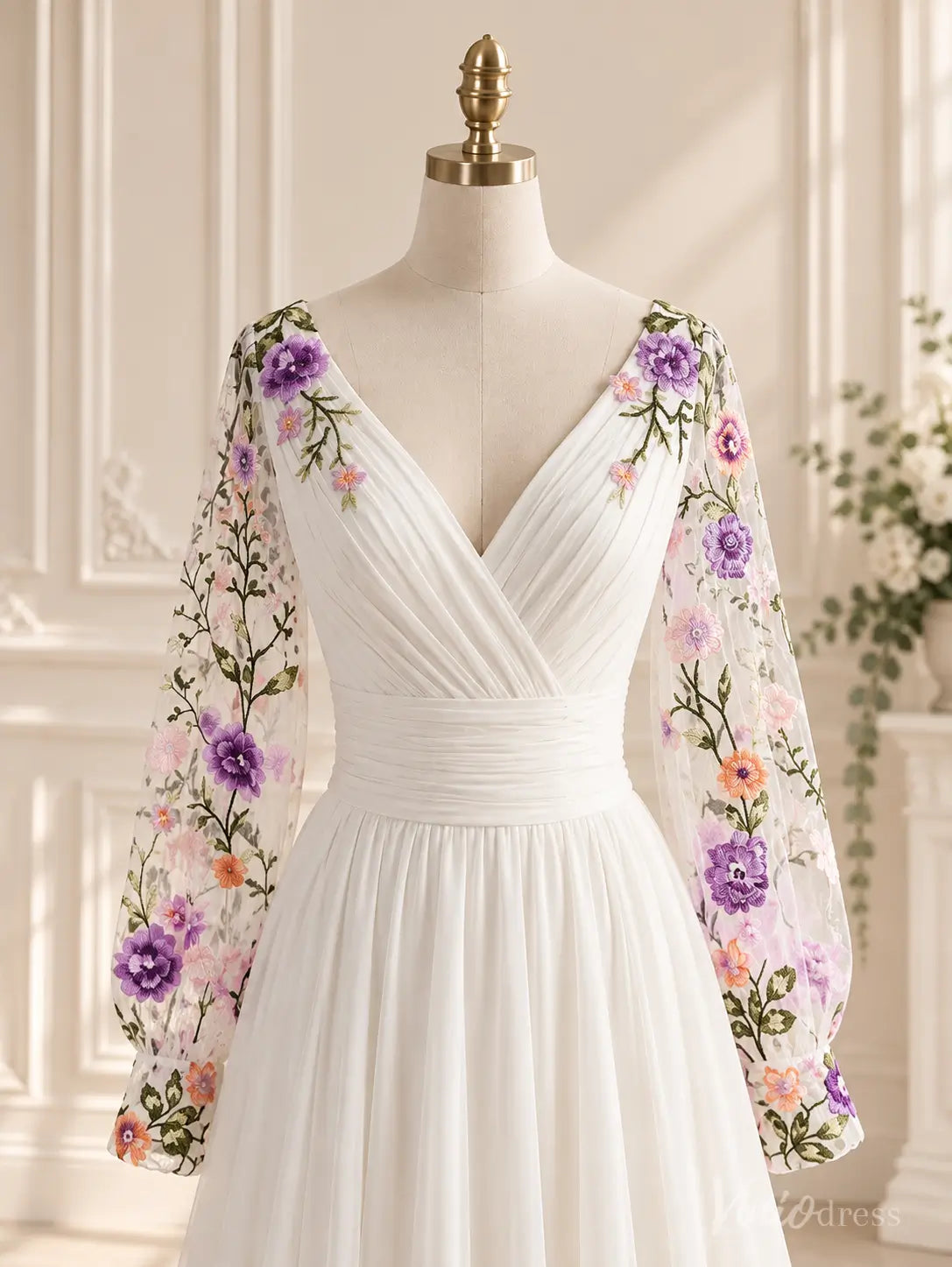 Ivory A-line wedding dress with pleated V-neck bodice, ruched waistband, and sheer bishop sleeves featuring colorful floral embroidery.