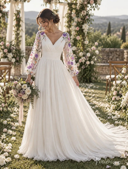 Ivory A-line wedding dress with floral embroidered bishop sleeves, ruched waistband, and flowing chiffon train in a garden.
