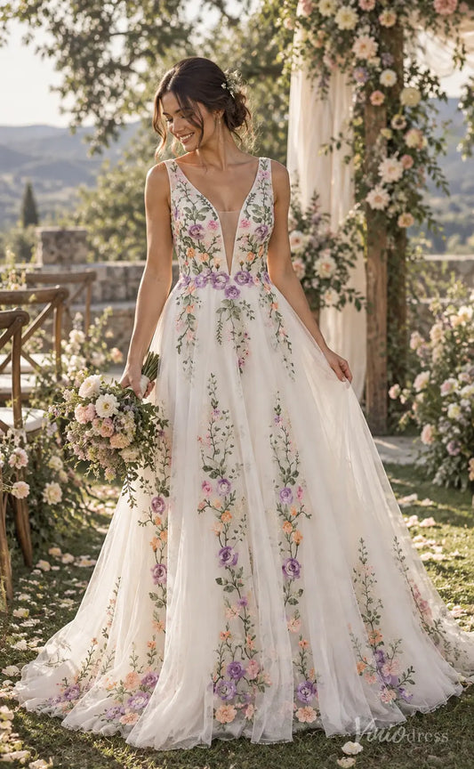 A-line wedding dress with colorful floral embroidery, plunging V-neck, and layered tulle skirt in a garden setting.