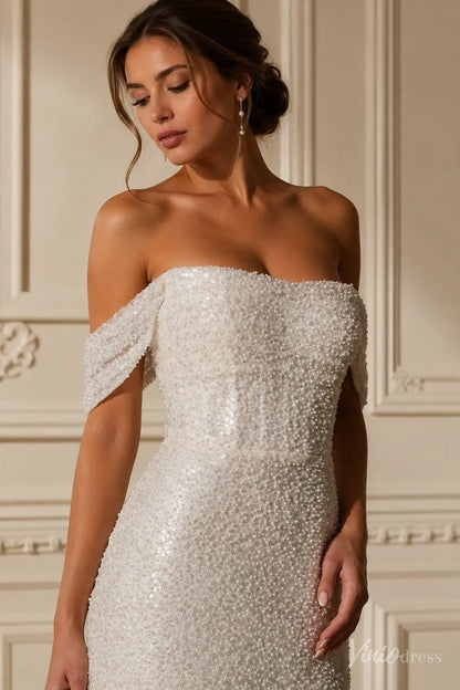 White off-the-shoulder wedding dress featuring a corset bodice fully embellished with intricate pearls and sequins.