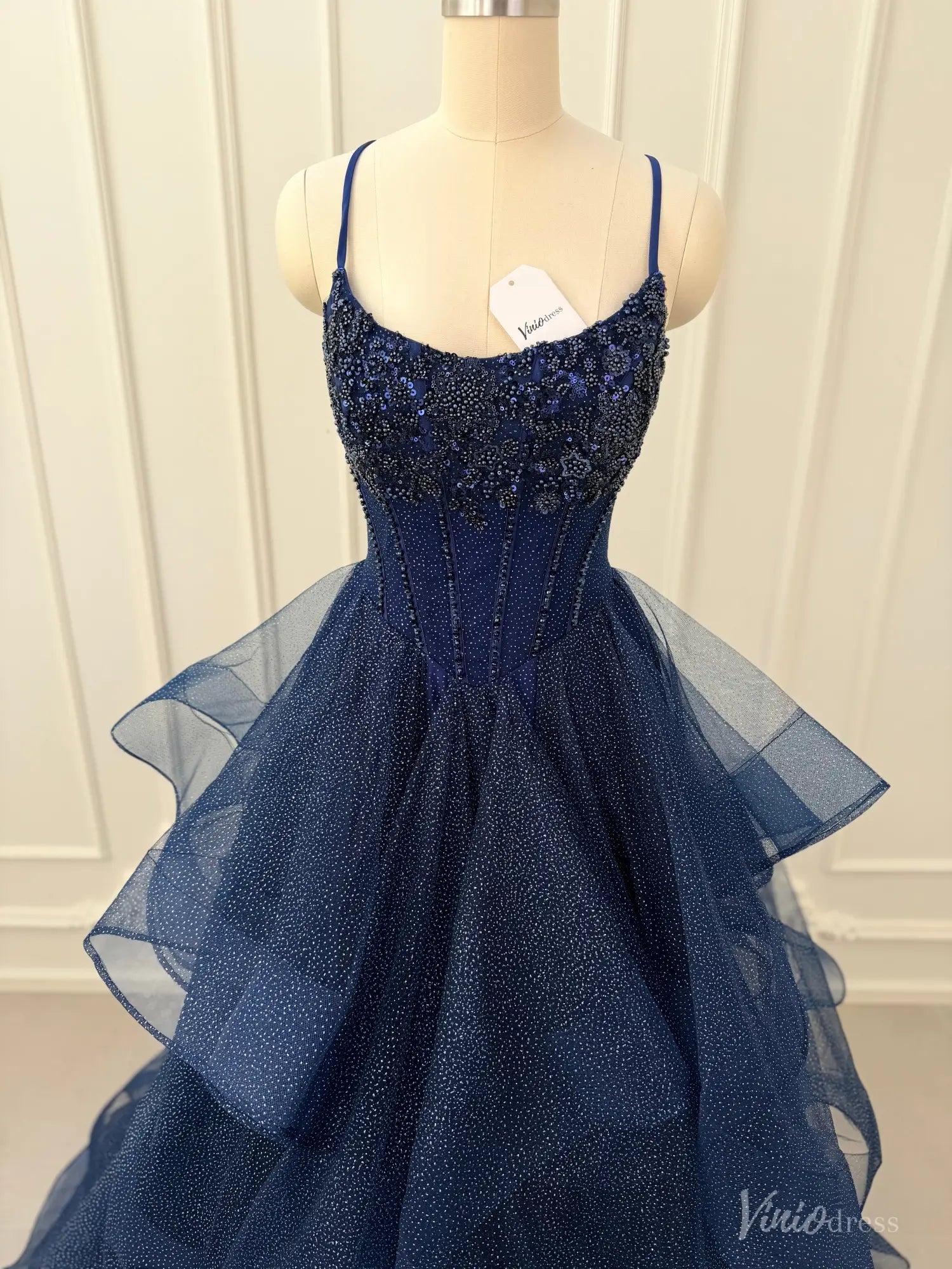 Navy blue glitter tulle prom dress with a beaded corset bodice and a dramatic tiered ruffle ball gown skirt.