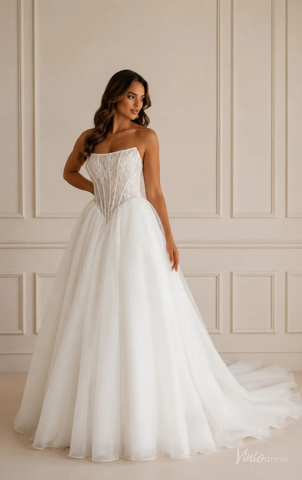 Ivory strapless ball gown with a lace corset bodice, basque waist, and full organza skirt with a chapel train.