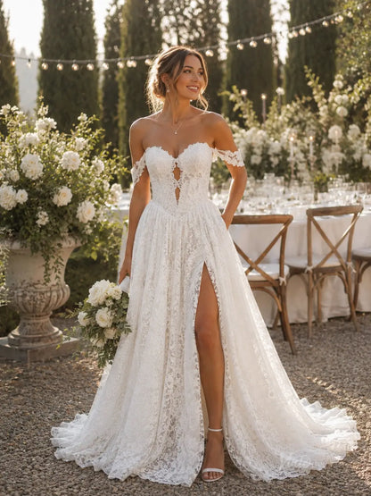White lace A-line wedding dress with off-the-shoulder sleeves, a sweetheart neckline, and a high leg slit.
