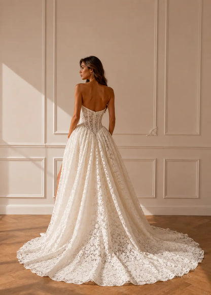 Strapless ivory lace wedding dress with a corset bodice and a full, floor-length A-line skirt with a train.