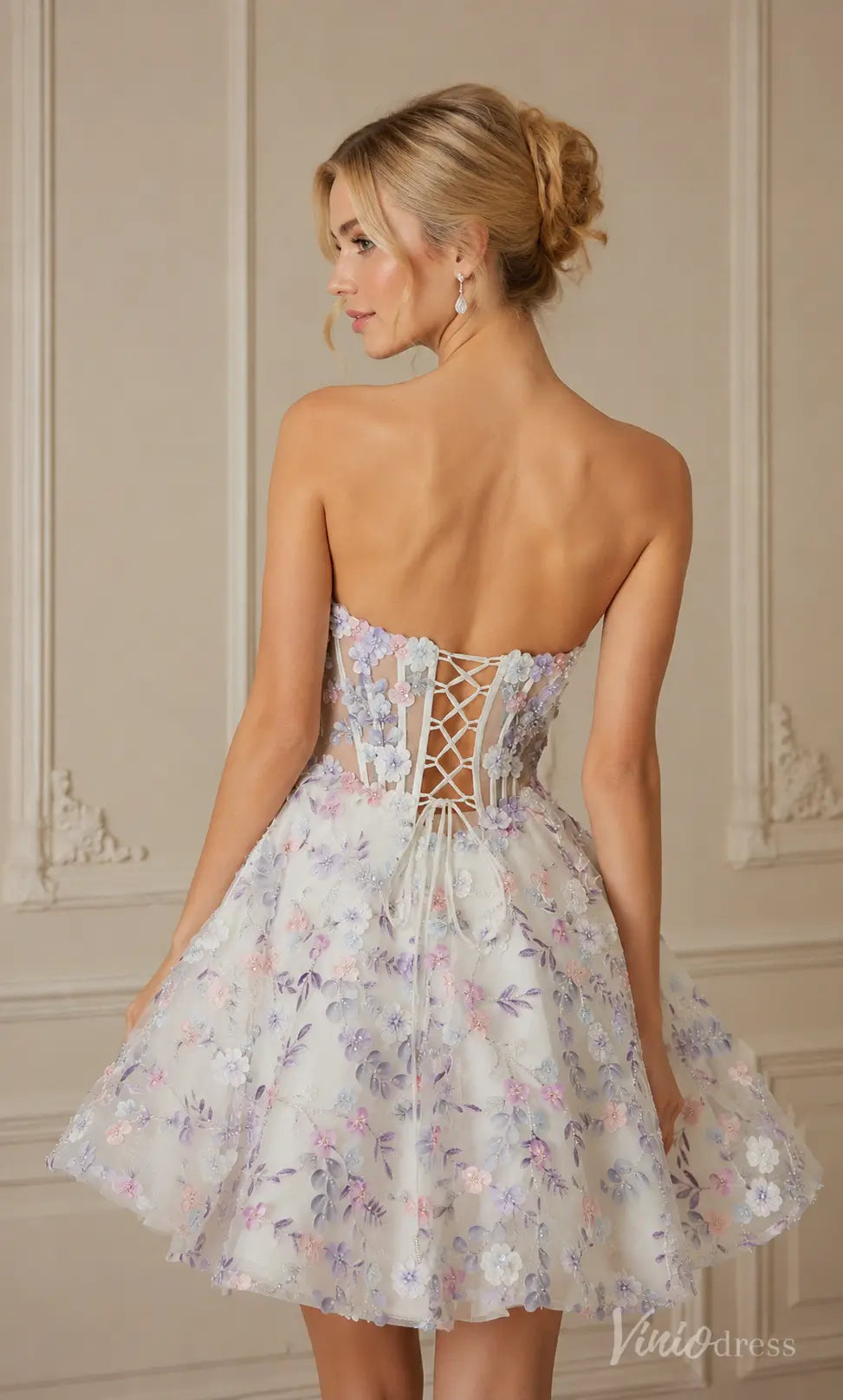 White strapless mini dress with purple and pink floral embroidery, a lace-up corset back, and a full skirt.