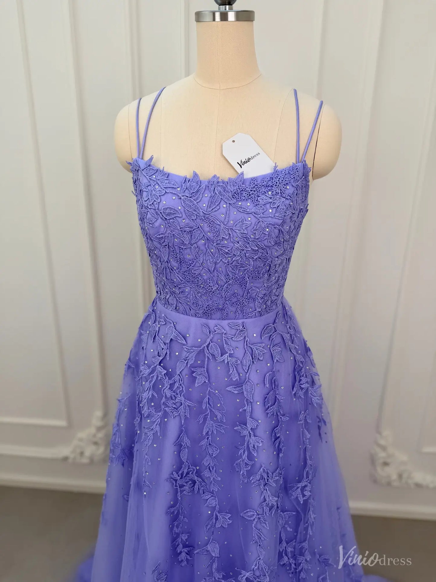 Lavender A-line prom dress with floral appliqué, sparkling embellishments, spaghetti straps, and a tulle skirt.