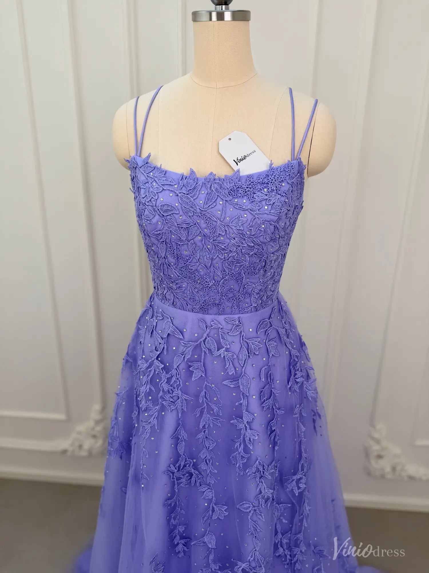 Lavender A-line prom dress with floral appliqué, sparkling embellishments, spaghetti straps, and a tulle skirt.