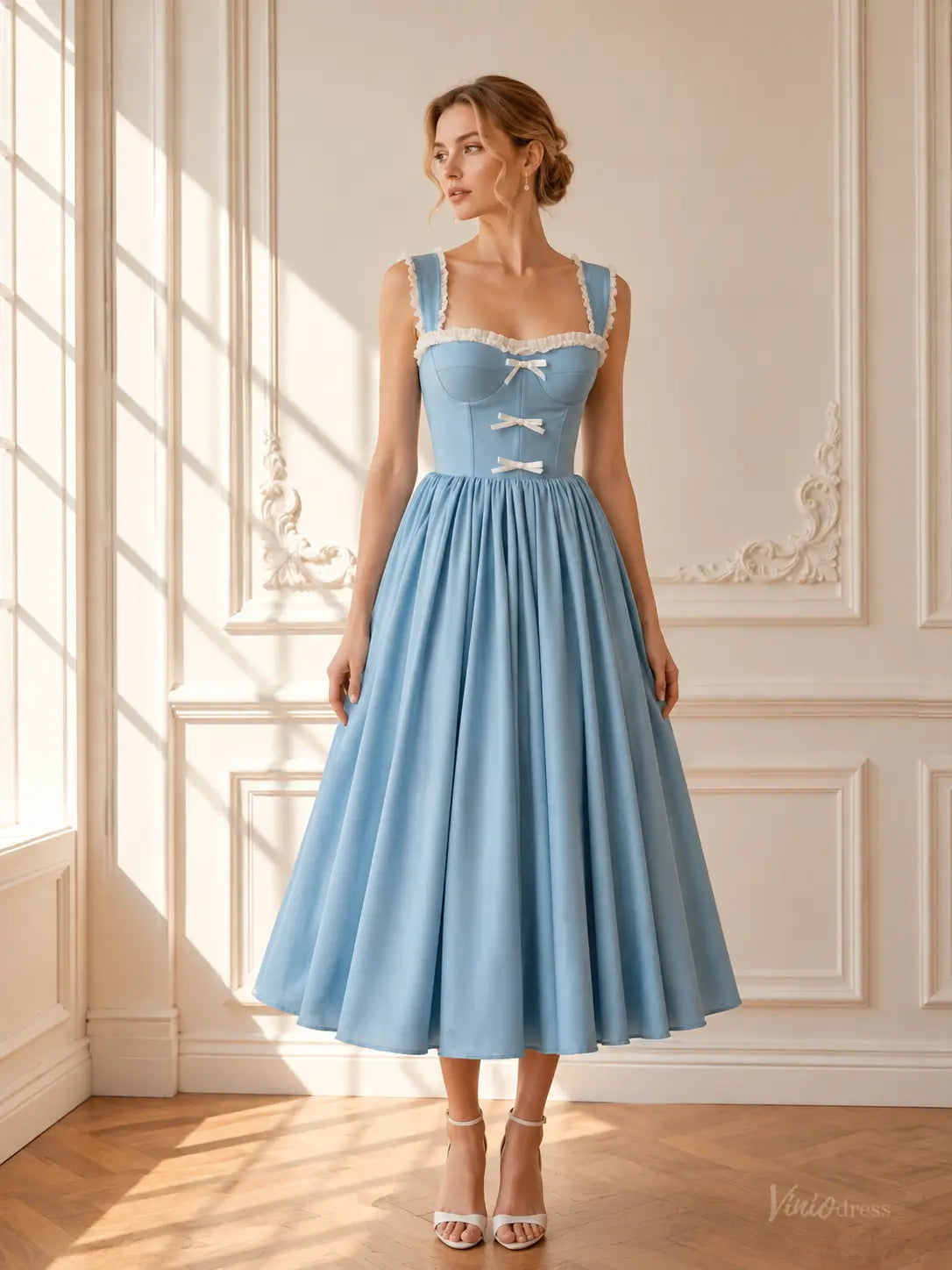 Light blue tea-length prom dress with a corset bodice, white ruffle trim, and delicate bow details.