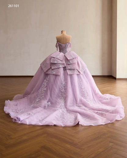 Lilac quinceañera ball gown with a crystal corset, layered back bow, and floral embroidered tulle skirt with a train.