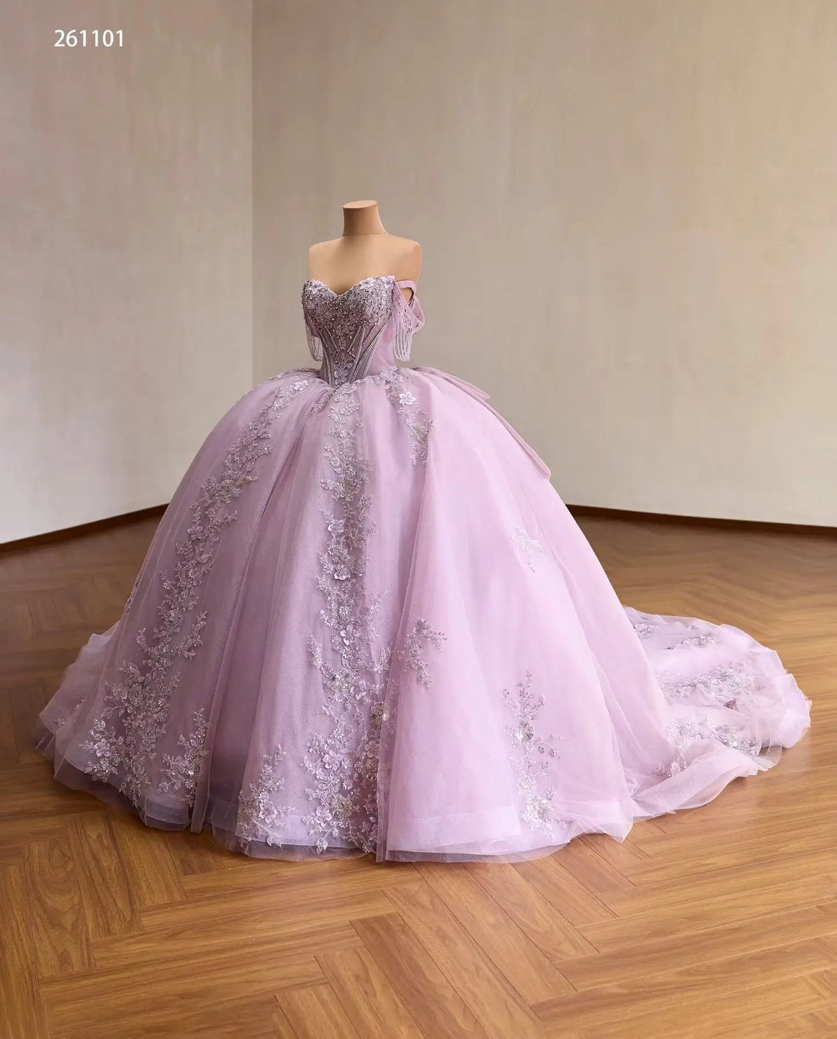 Lilac off-shoulder quinceañera ball gown with a crystal corset, 3D floral appliqués, and a full embroidered tulle skirt.