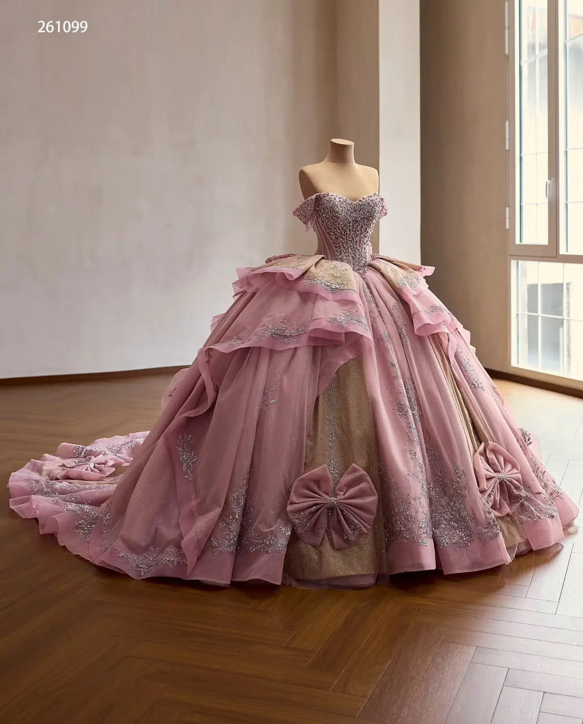 Dusty pink off-shoulder ball gown with silver beaded corset bodice, tiered skirt, and oversized bow accents.