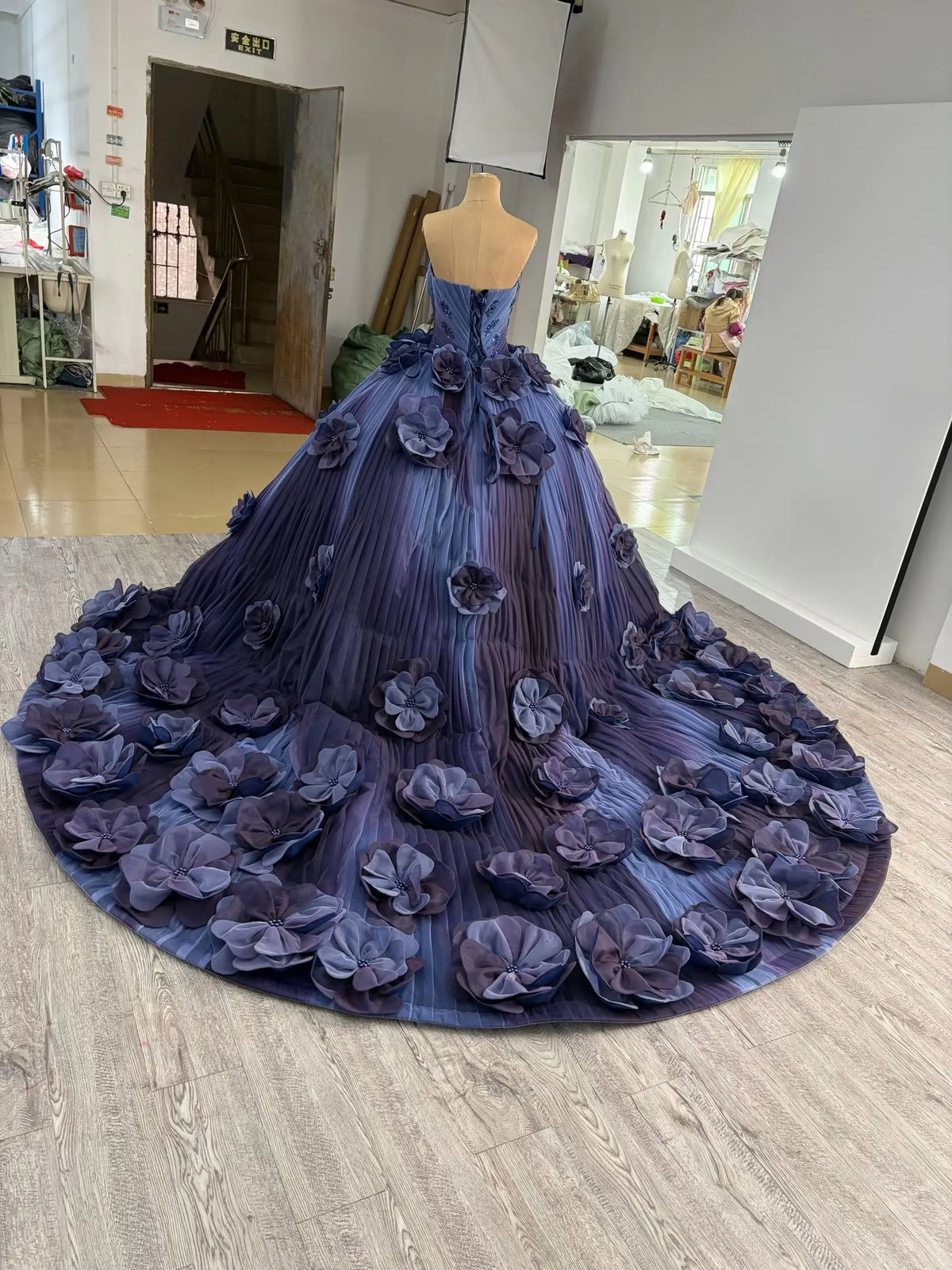 Luxury navy blue ball gown with 3D floral appliqués, sweetheart neckline, and a dramatic 1-meter train on a mannequin.