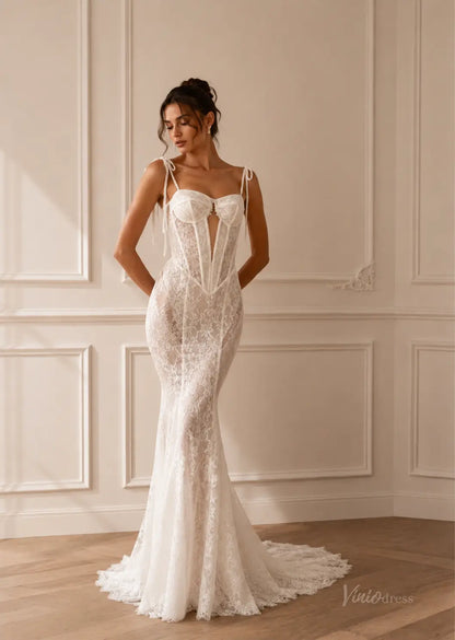 White lace mermaid wedding dress with a corset bodice, deep plunge neckline, and delicate tie-up spaghetti straps.