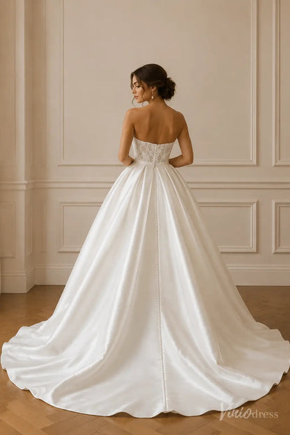 Strapless ivory satin ballgown wedding dress with a lace bodice, full skirt, and a row of elegant back buttons.