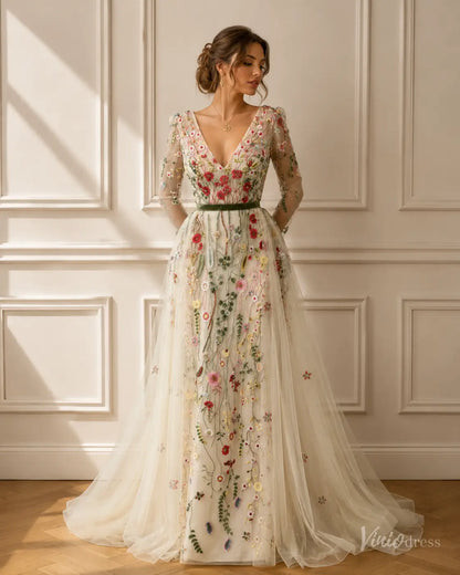 V-neck mermaid wedding dress with sheer long sleeves, tulle overskirt, and colorful meadow floral embroidery.