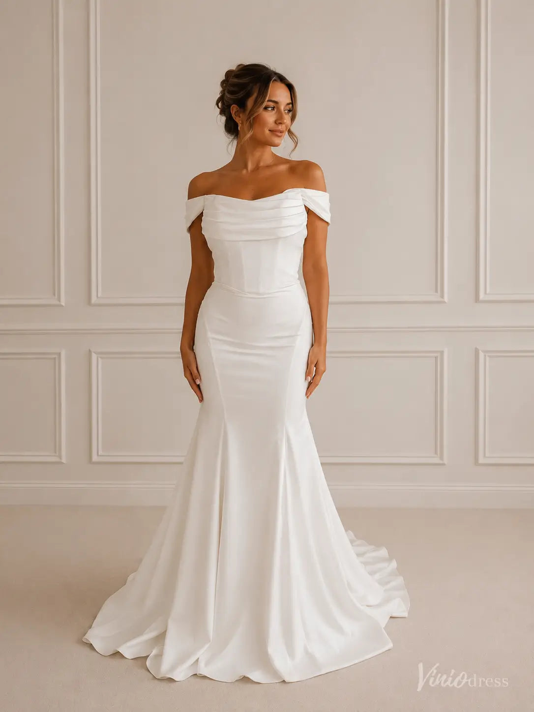 Minimalist white crepe mermaid wedding dress with an off-shoulder folded neckline and structured corset bodice.