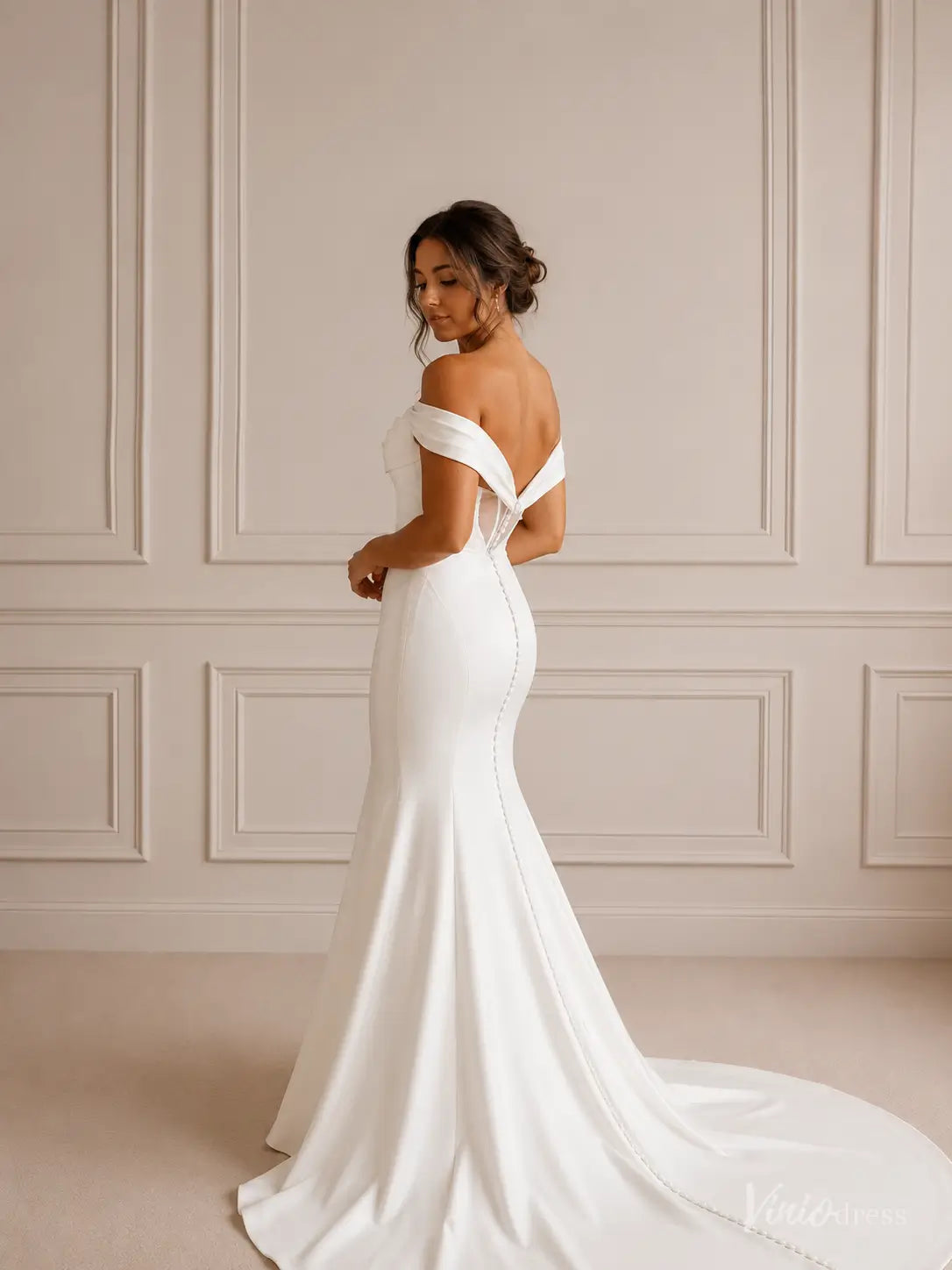 Minimalist white crepe mermaid wedding dress with off-shoulder folded neckline and button-down train.