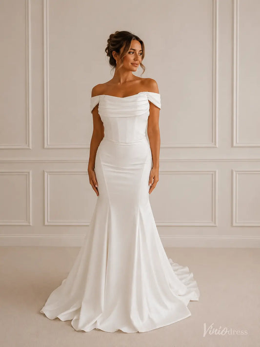 Minimalist white crepe mermaid wedding dress with an off-shoulder folded neckline and structured corset bodice.