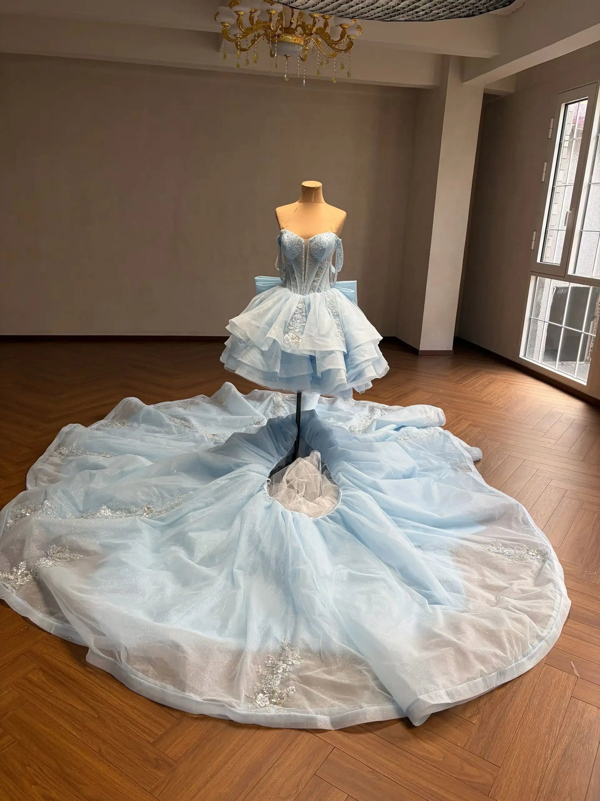 Mint green convertible quinceañera dress with a beaded corset bodice, tiered ruffle skirt, and detachable sweeping overskirt.