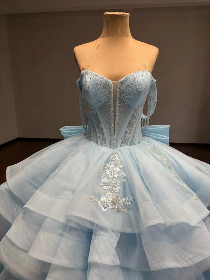 Mint green convertible quinceañera ball gown with beaded corset bodice, floral appliqué, and a detachable ruffled overskirt.