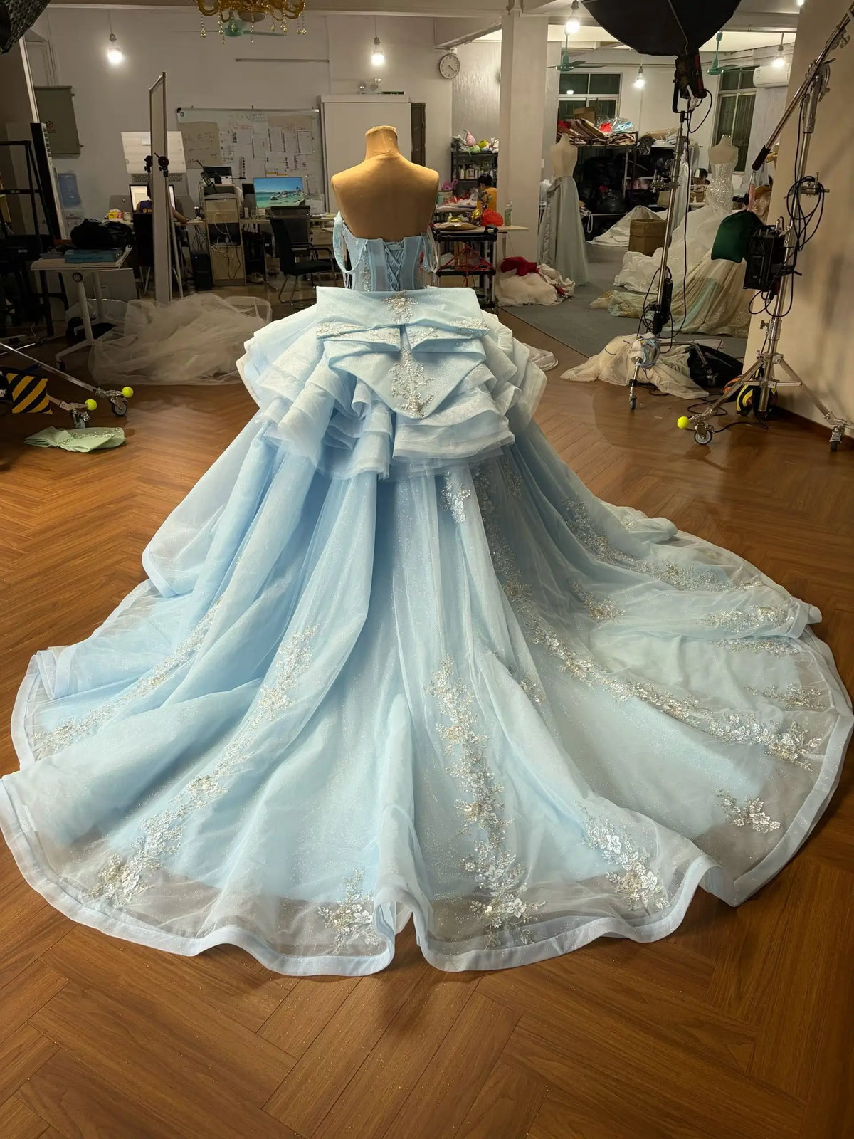 Mint green convertible ball gown with a detachable ruffled overskirt, beaded floral appliqué, and a large back bow.