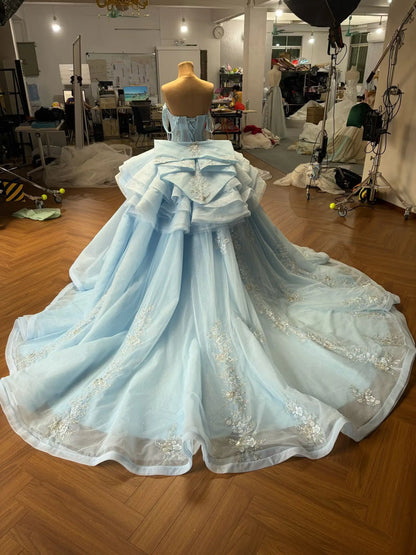 Mint green convertible ball gown with a detachable ruffled overskirt, beaded floral appliqué, and a large back bow.