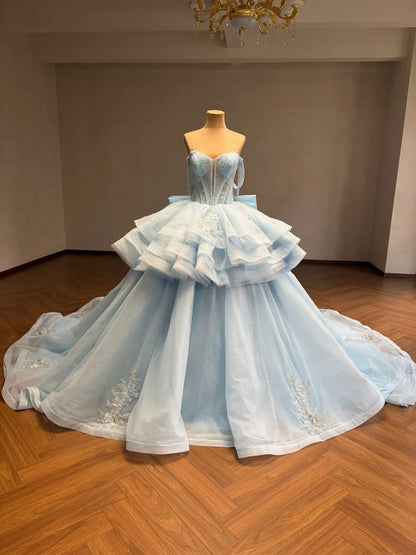Mint green convertible quinceañera ball gown with a beaded corset bodice, tiered ruffled overskirt, and floral appliqué.