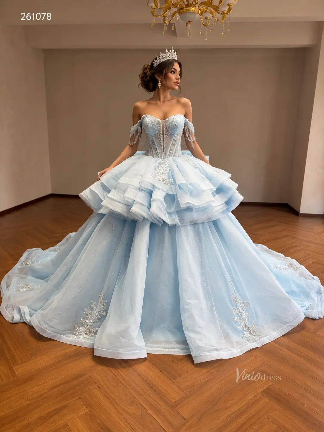 Mint green convertible ball gown with beaded corset bodice, off-shoulder sleeves, ruffled overskirt, and floral appliqué.