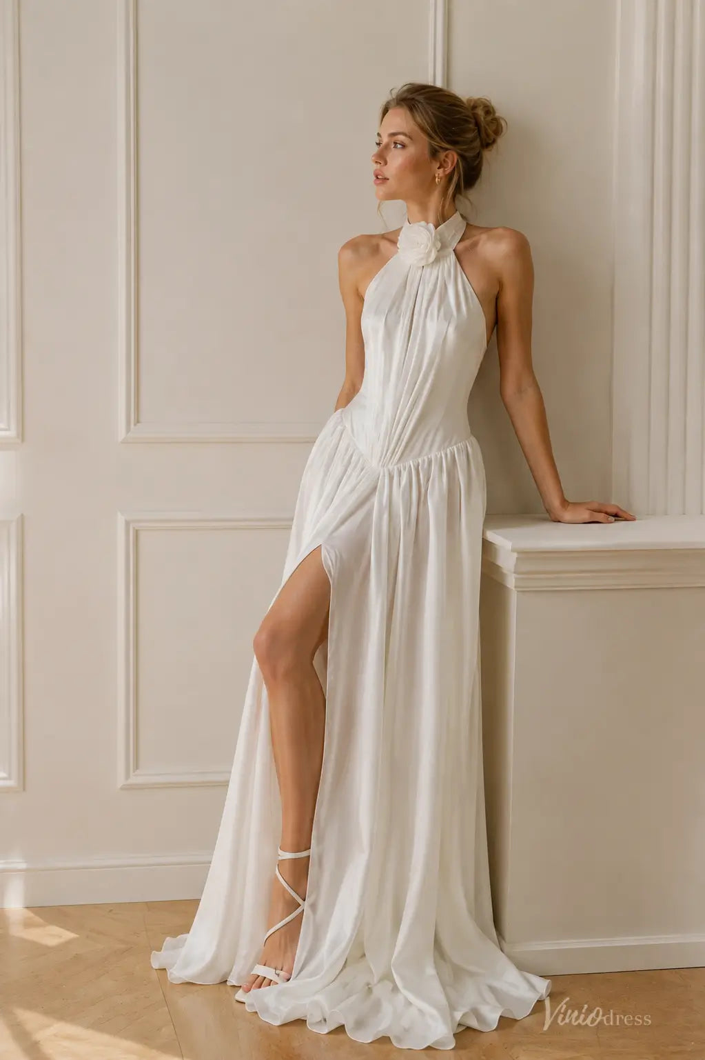 White A-line chiffon beach wedding dress featuring a halter neckline with floral detail and a high side slit.