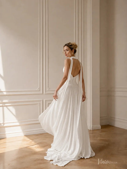 White A-line chiffon beach wedding dress with a halter neckline, open back, and flowing skirt with a side slit.