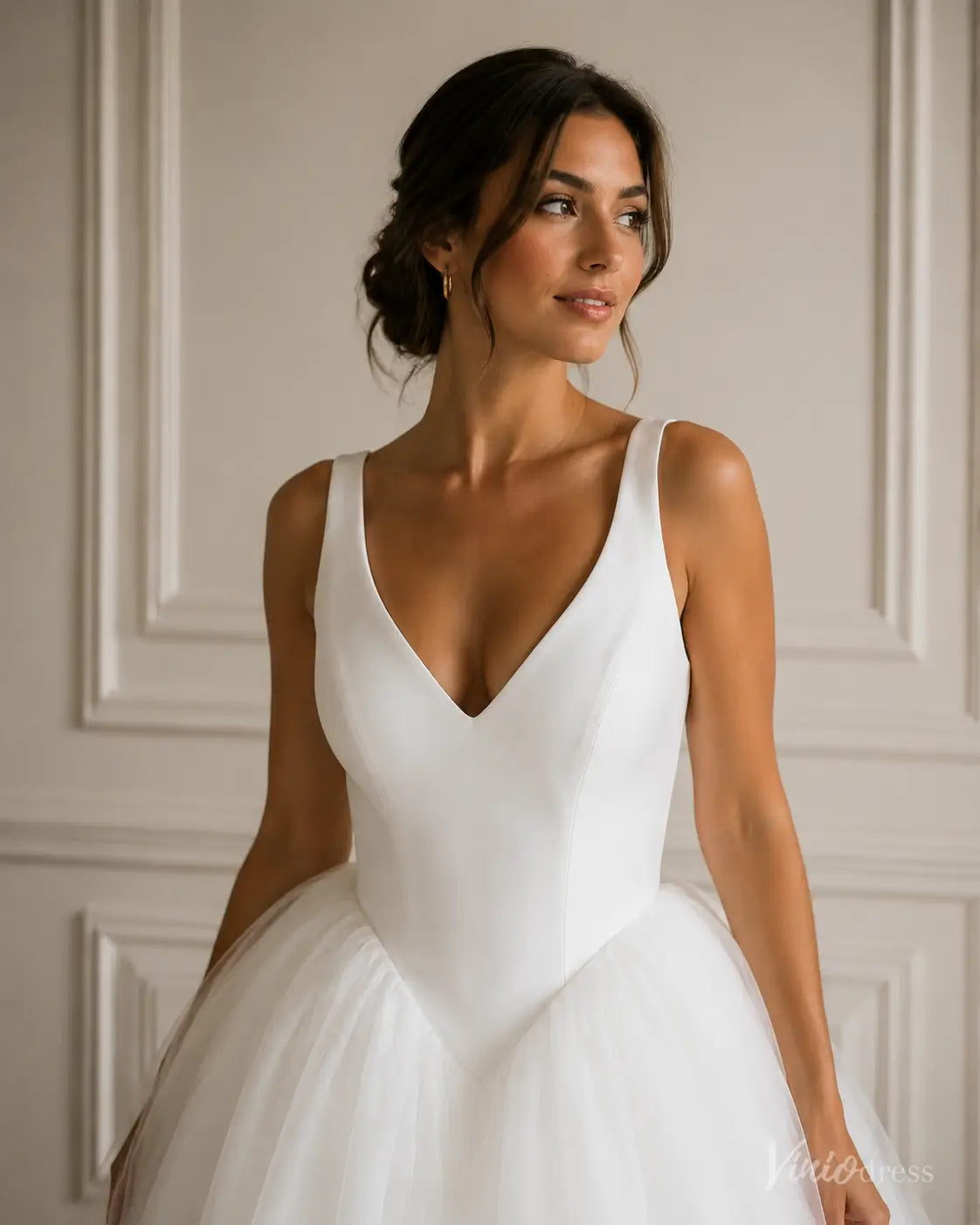Elegant white wedding dress with a V-neck bodice, thick straps, and a voluminous layered tulle skirt.