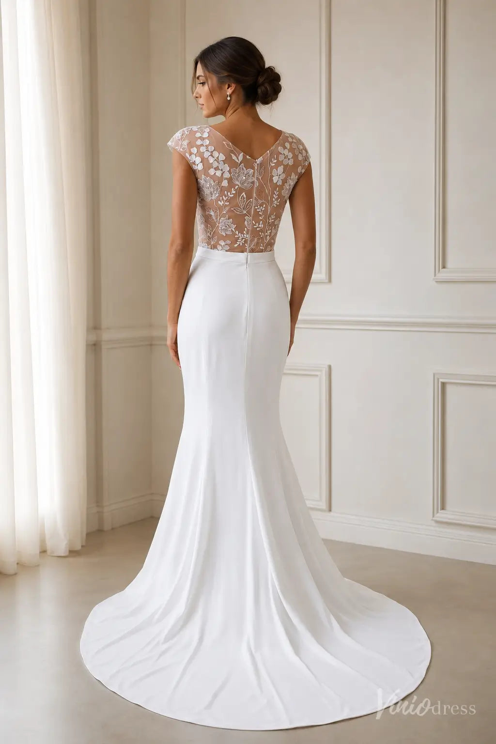 Modern white crepe mermaid wedding dress with a sheer illusion back and delicate floral lace embroidery.