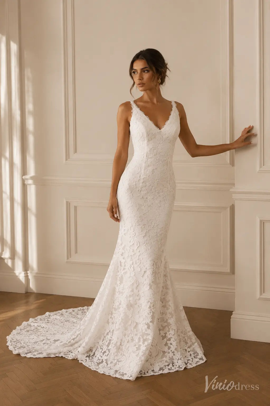 White lace mermaid wedding dress with a V-neckline, thin straps, and a delicate floor-length train.