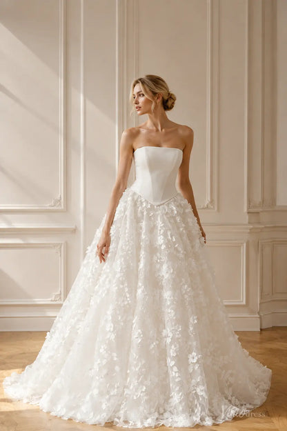 White strapless ballgown wedding dress with a structured corset bodice and a full skirt featuring 3D floral appliqués.