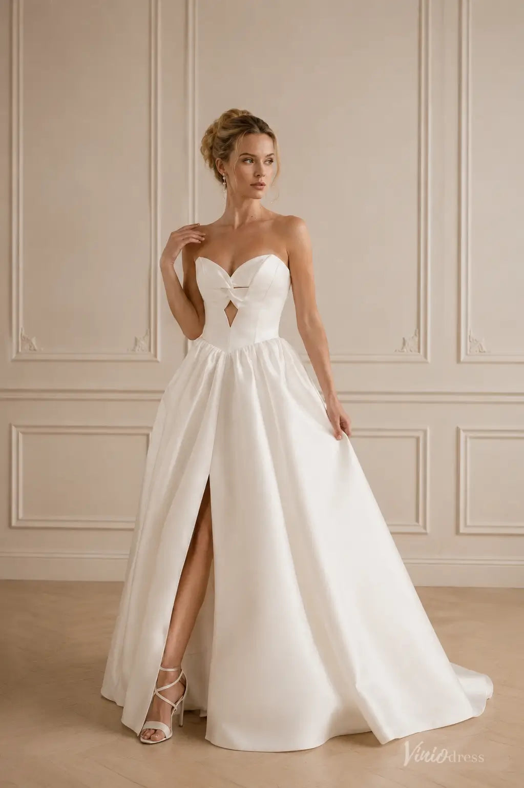 Ivory satin A-line wedding dress with a strapless twist-front sweetheart bodice, diamond cutout, and high leg slit.