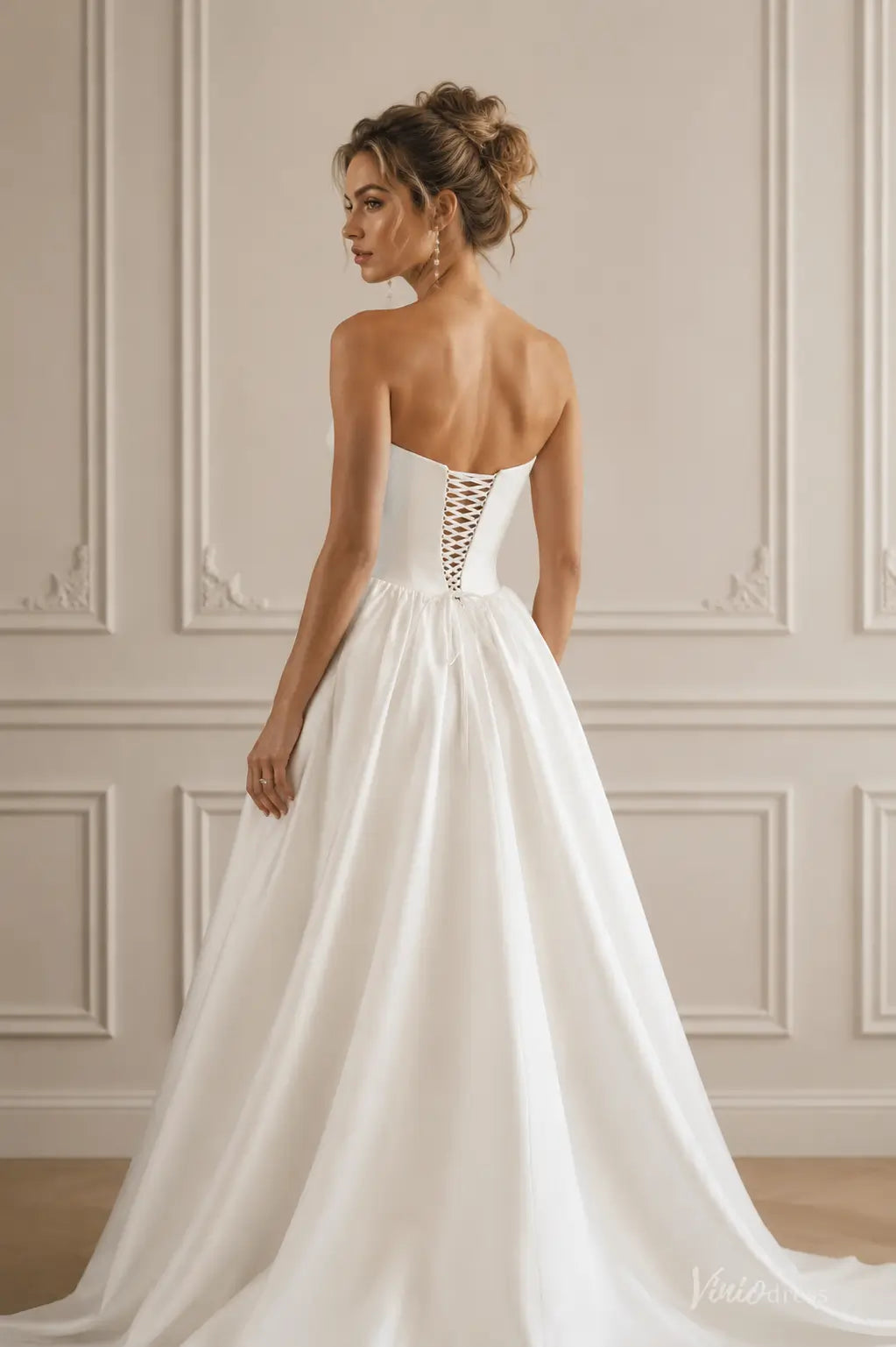 Ivory satin A-line wedding dress featuring a strapless sweetheart bodice and a lace-up corset back.