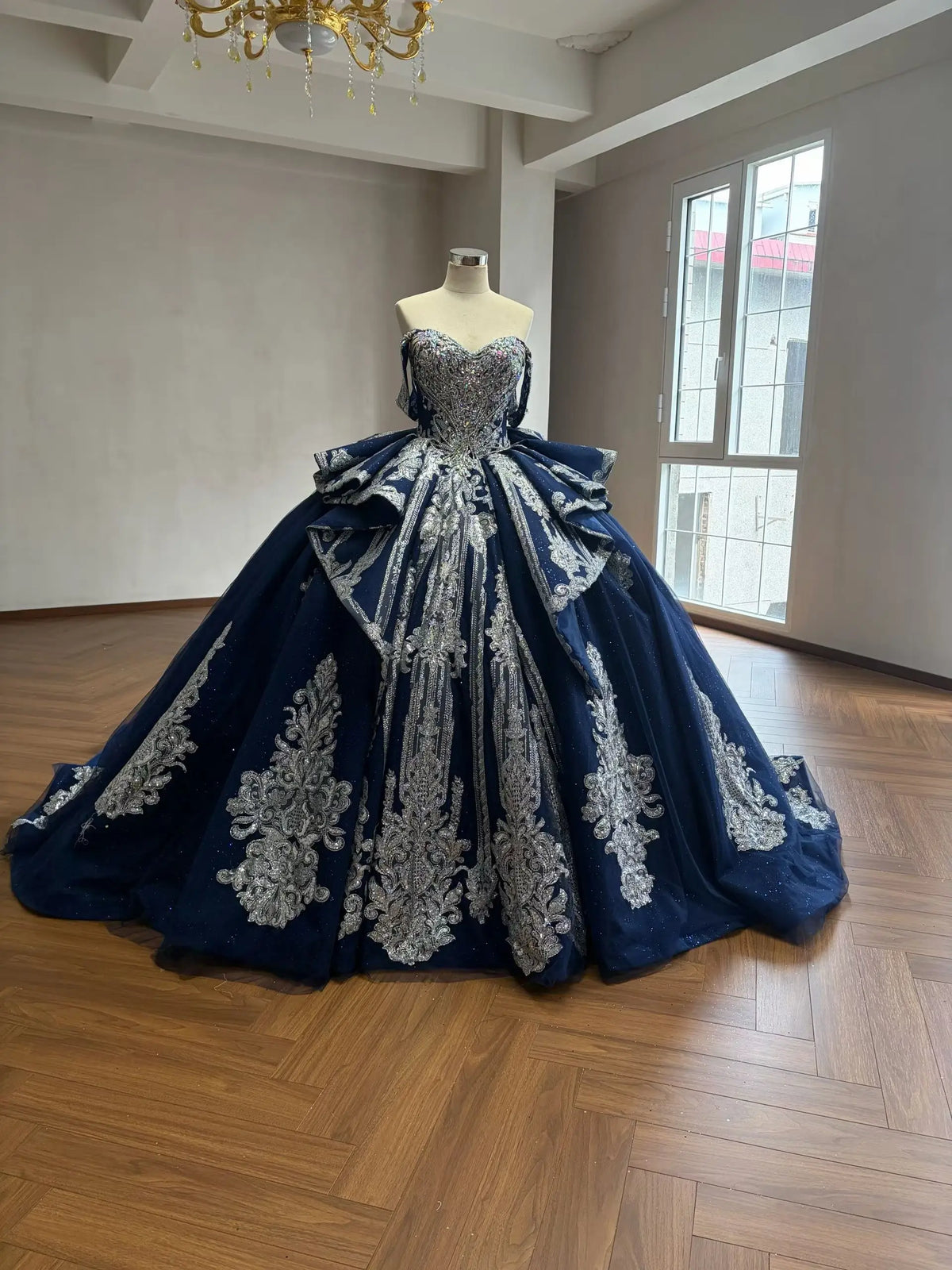 Navy blue ball gown with silver baroque embroidery, crystal corset bodice, off-shoulder straps, and cathedral train.