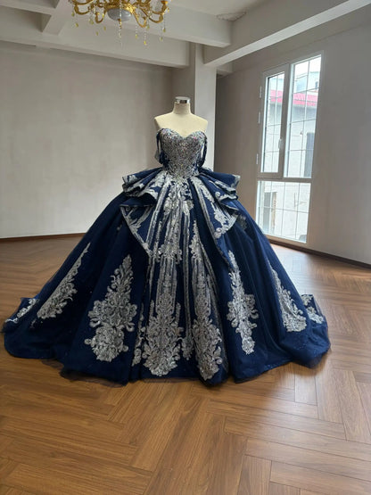 Navy blue ball gown with silver baroque embroidery, crystal corset bodice, off-shoulder straps, and cathedral train.