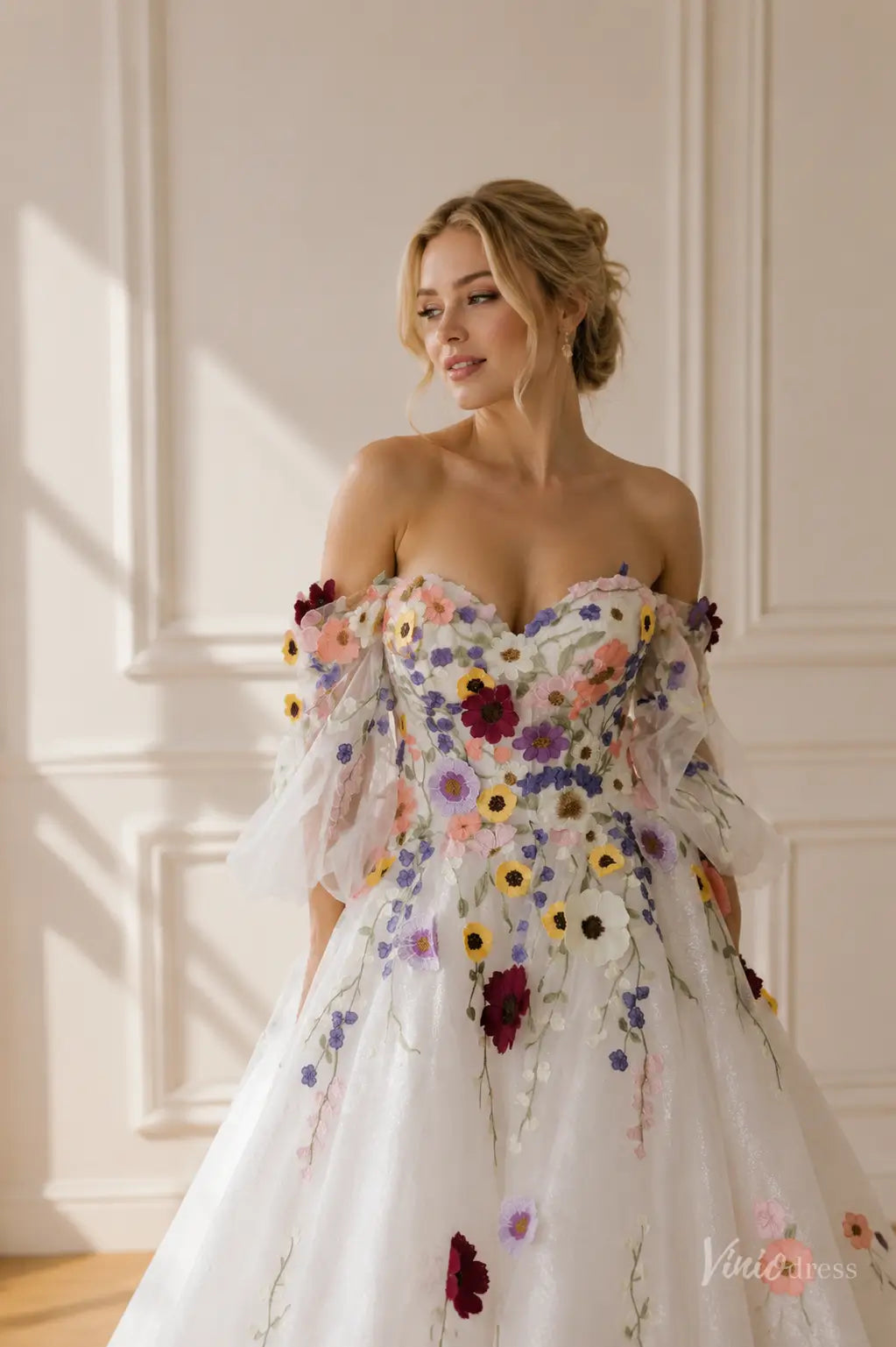 Off-the-shoulder ball gown with colorful floral embroidery, detachable puff sleeves, and a romantic sweetheart neckline.