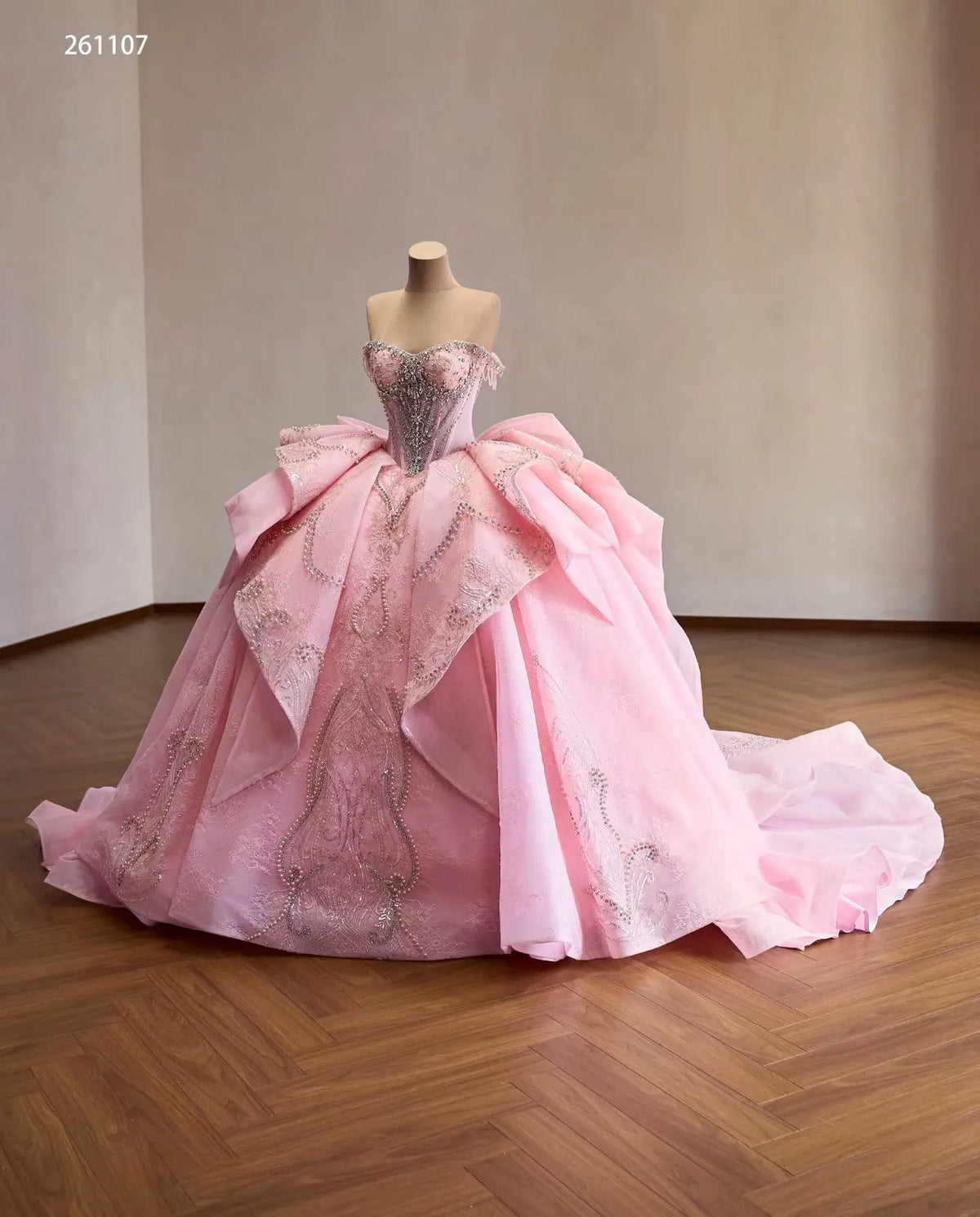 Pink off-shoulder quinceañera dress with crystal corset, layered overskirt, and dramatic structured back bow.
